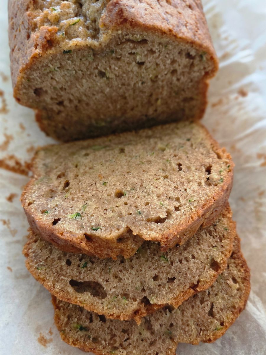 Close-up of sliced cinnamon zucchini bread showing tender crumb and specks of fresh zucchini